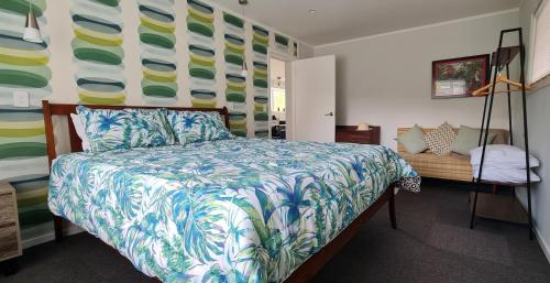 a bedroom with a bed with a colorful bedspread and a desk at Waikanae Beach Suite Retreat in Waikanae