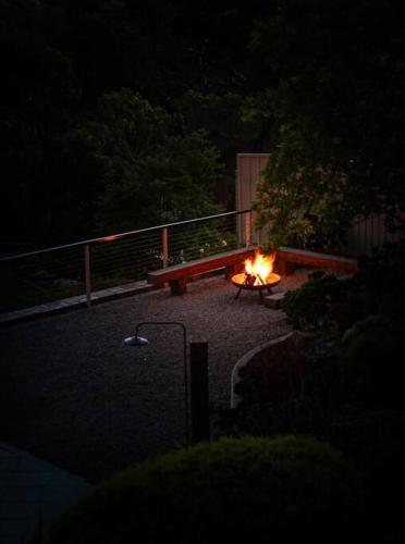 a fire pit with a bench in a yard at night at Sand Road Estate in McLaren Flat