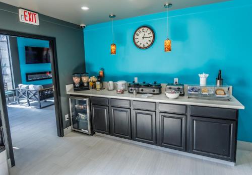 a kitchen with a clock on a blue wall at Baymont by Wyndham Branson Thousand Hills in Branson