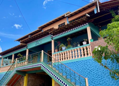 une maison bleue avec un balcon orné de plantes. dans l'établissement Hospedaria do Tom, à Lençóis