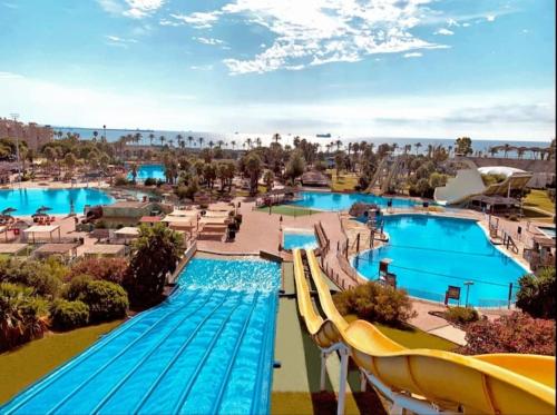 ein Resort mit 2 Pools und einem Wasserpark in der Unterkunft Pineda apartamento de playa in La Pineda