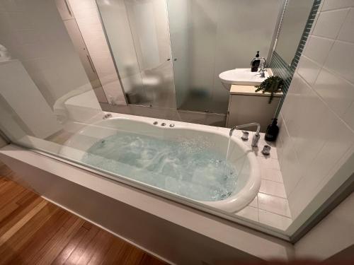y baño con bañera y lavamanos. en Tranquil Spa Suite, K-bed, Plunge Pool at Kingscliff Salt Beach Resort and Spa, en Kingscliff