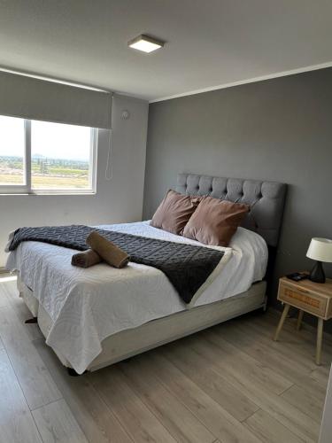 a bedroom with a large bed with a large window at DEPTO cercano a HHRR, calefacción en living y piezas, estacionamiento privado, cercano a carretera paramericana 5 y safari de Rancagua,wifi in Rancagua