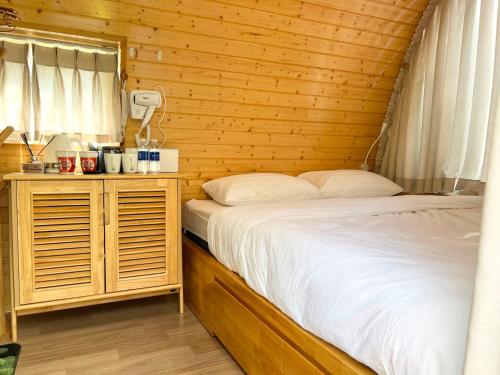 a bedroom with a bed and a wooden wall at Lê Đinh’s House in Di Linh
