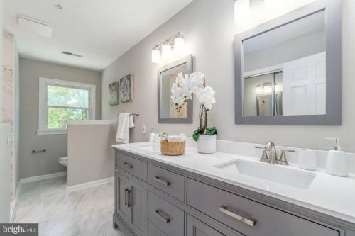 a bathroom with a sink and a mirror at Tara Retreat: Family-Friendly Oasis with Pool, Tennis & Serene Ambiance in Potomac in Potomac