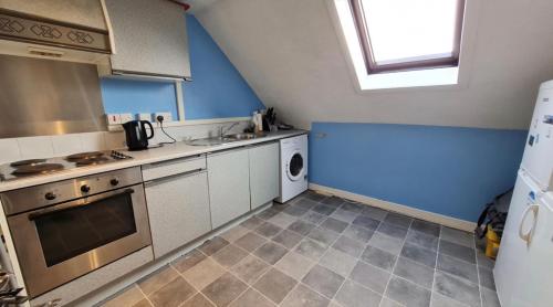 uma pequena cozinha com um fogão e um lavatório em Orkney lux apartment em Orkney