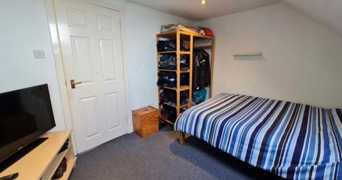 オークニー諸島にあるOrkney lux apartmentのベッドルーム(ベッド1台、テレビ、クローゼット付)