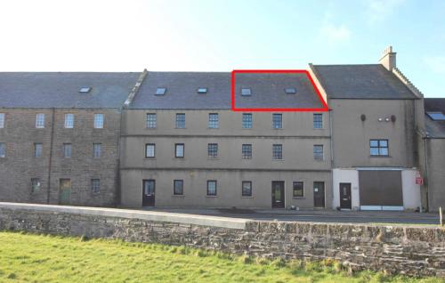 um grande edifício de tijolos com telhado vermelho em Orkney lux apartment em Orkney