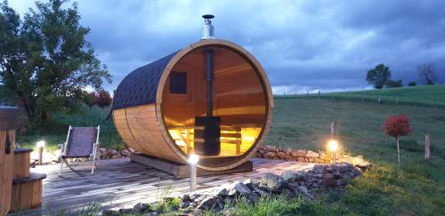 a wooden circle shaped pod sitting on a wooden deck at Gîte de l'Âne vert in Lay