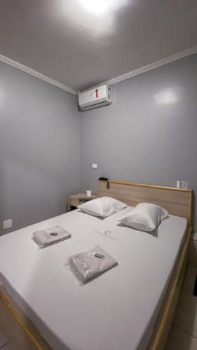a large white bed with two towels on it at Hotel city Clélia in Sao Paulo
