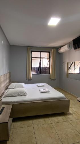 a large bed in a room with a window at Hotel city Clélia in Sao Paulo