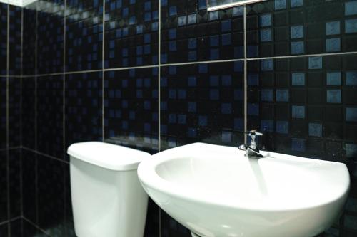 a bathroom with a white toilet and a sink at Hotel city Clélia in Sao Paulo