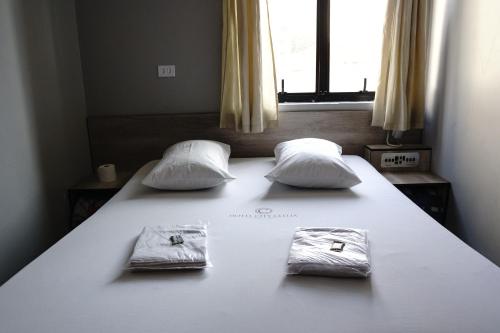 a large white bed with two pillows on it at Hotel city Clélia in Sao Paulo
