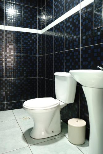 a bathroom with a toilet and a sink at Hotel city Clélia in Sao Paulo