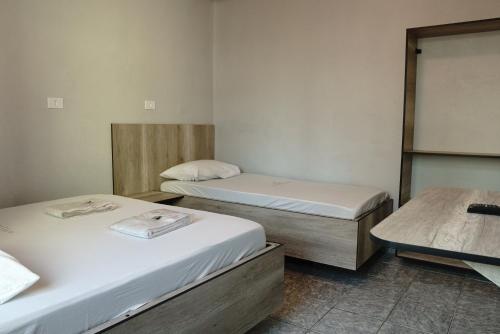 a room with two beds and a table in it at Hotel city Clélia in Sao Paulo