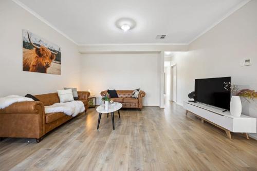 a living room with a couch and a tv at The Charming Living 3BR Townhouse Perfect Vacation in Birkenhead