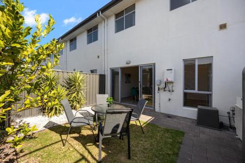 a patio with a table and chairs in front of a building at The Charming Living 3BR Townhouse Perfect Vacation in Birkenhead