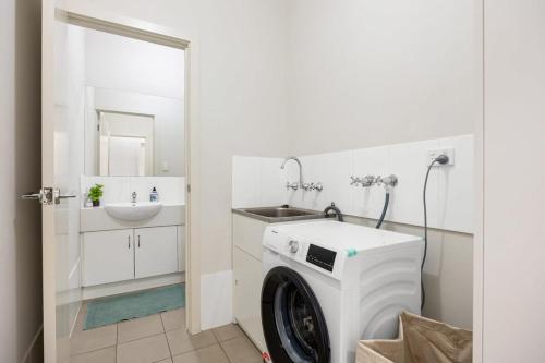 a washing machine in a bathroom with a sink at The Charming Living 3BR Townhouse Perfect Vacation in Birkenhead