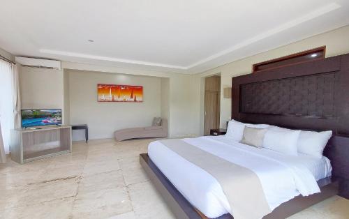 a bedroom with a large bed and a television at Villa Harmony - Residence in Seminyak