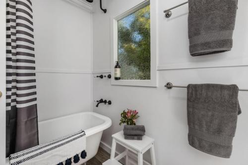 un bagno con vasca e finestra di Captains Cottage - Huskisson a Huskisson