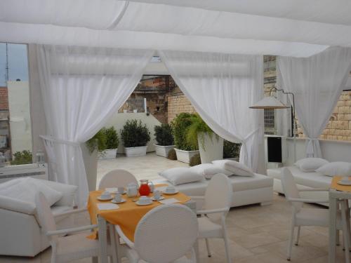 a living room with a couch and a table and chairs at Palazzo Antica Via Appia in Bitonto