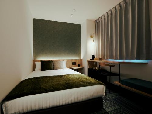a bedroom with a large bed and a window at R Hotel Kansai Airport in Izumi-Sano