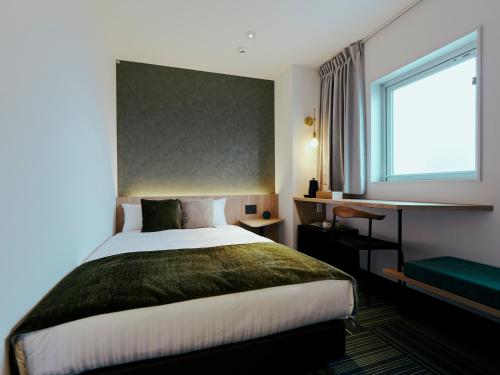 a hotel room with a bed and a window at R Hotel Kansai Airport in Izumi-Sano