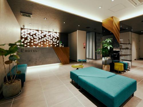 a hotel lobby with a blue bed and chairs at R Hotel Kansai Airport in Izumi-Sano