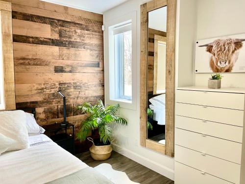 a bedroom with a wooden accent wall and a mirror at Svetlana et Dominick in Joliette