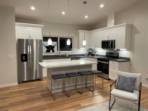 a kitchen with white cabinets and a kitchen island with bar stools at Bright Napa Home in Napa