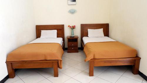 2 Betten nebeneinander in einem Zimmer in der Unterkunft Samudra Hotel in Jepara