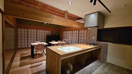 a kitchen with a sink and a table in it at ゲストハウス奥屋敷城内 in Kinko