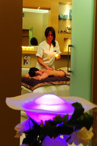 a woman giving a man a massage in a room at BV Grand Hotel Assisi in Assisi