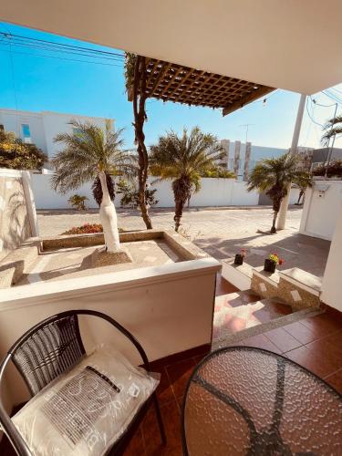 a patio with a table and a chair and palm trees at Casa en Punta Barandua in Punta Blanca