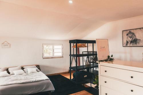 a bedroom with a bed and a dresser in it at Casa de praia in Estoril