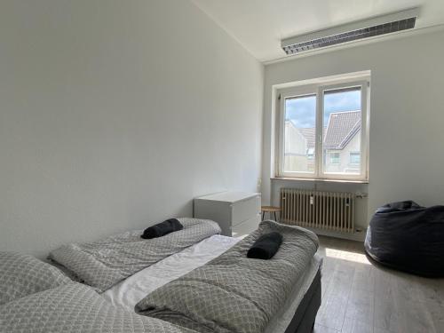 2 Betten in einem Zimmer mit Fenster in der Unterkunft Simplex Apartments Am Marktplatz in Karlsruhe