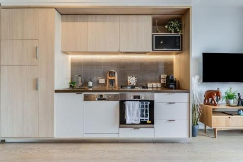 a kitchen with white cabinets and a stove top oven at TASTE of African Luxury in the Heart of Brisbane in Brisbane
