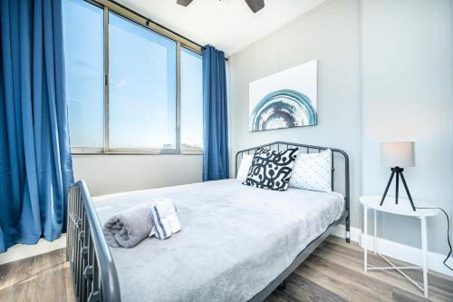 a bedroom with a bed with blue curtains at Atlanta Downtown! High Rise! Onsite Parking LM1903 in Atlanta