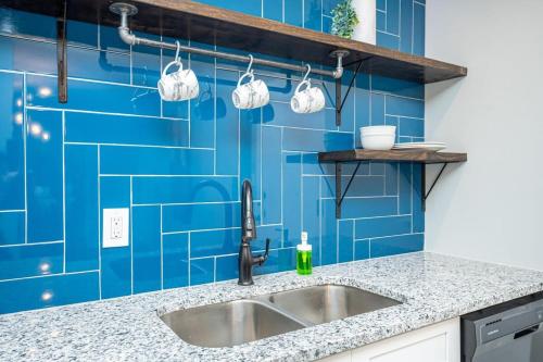 cocina con fregadero y pared de azulejos azules en Atlanta Downtown! High Rise! Onsite Parking LM1903, en Atlanta