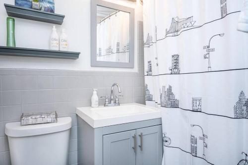 a bathroom with a sink and a toilet and a shower curtain at Heart Downtown! City View Onsite Parking! King Bed LM807 in Atlanta