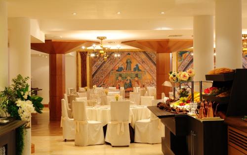 a dining room with white tables and white chairs at BV Grand Hotel Assisi in Assisi