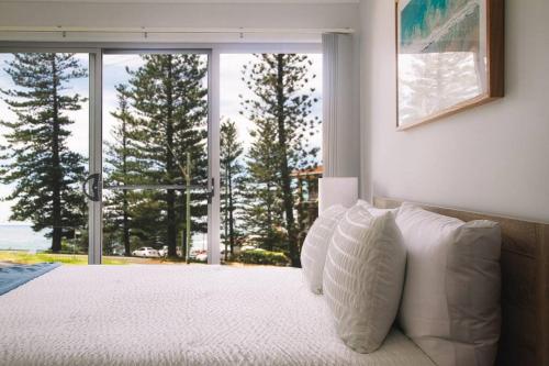 ヤンバにあるBay Property . The Seasprayのベッドルーム1室(白い枕のベッド1台、窓付)