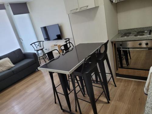 cocina y sala de estar con mesa y sillas en Departamento Brisa del sol en Talcahuano