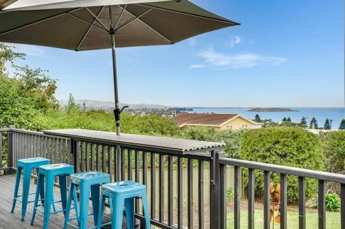 a deck with three blue stools and an umbrella at 48 Rumbelow St - BYO Linen - Sea Views - Family Friendly in Encounter Bay
