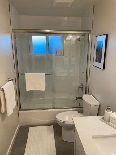 a white bathroom with a shower and a toilet at Bright Napa Home in Napa