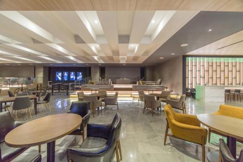 un restaurante con mesas y sillas y una cafetería en Dignity Hotel, en Yangyang