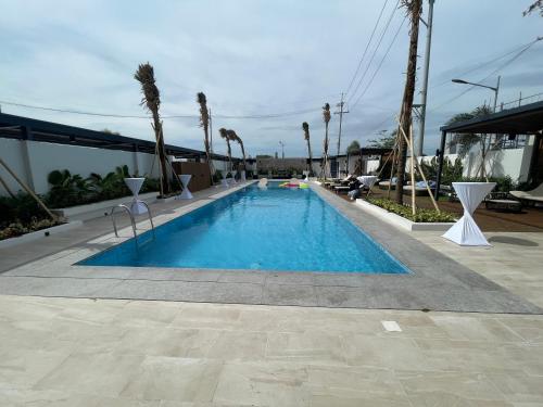 einen Pool in einem Resort mit Palmen in der Unterkunft Acro Residences in Guiguinto
