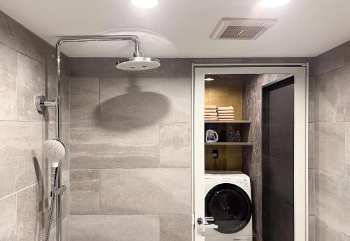 a bathroom with a washing machine in a shower at NEXUS HOTEL Gotanda in Tokyo