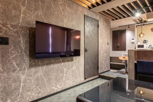 a bathroom with a large tv on a wall at NEXUS HOTEL Gotanda in Tokyo