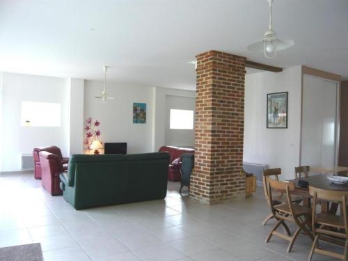 a living room with a couch and a brick pillar at Gîte spacieux, confort moderne, nature et tranquillité près de Tours et des châteaux de la Loire - FR-1-381-273 in Le Boulay